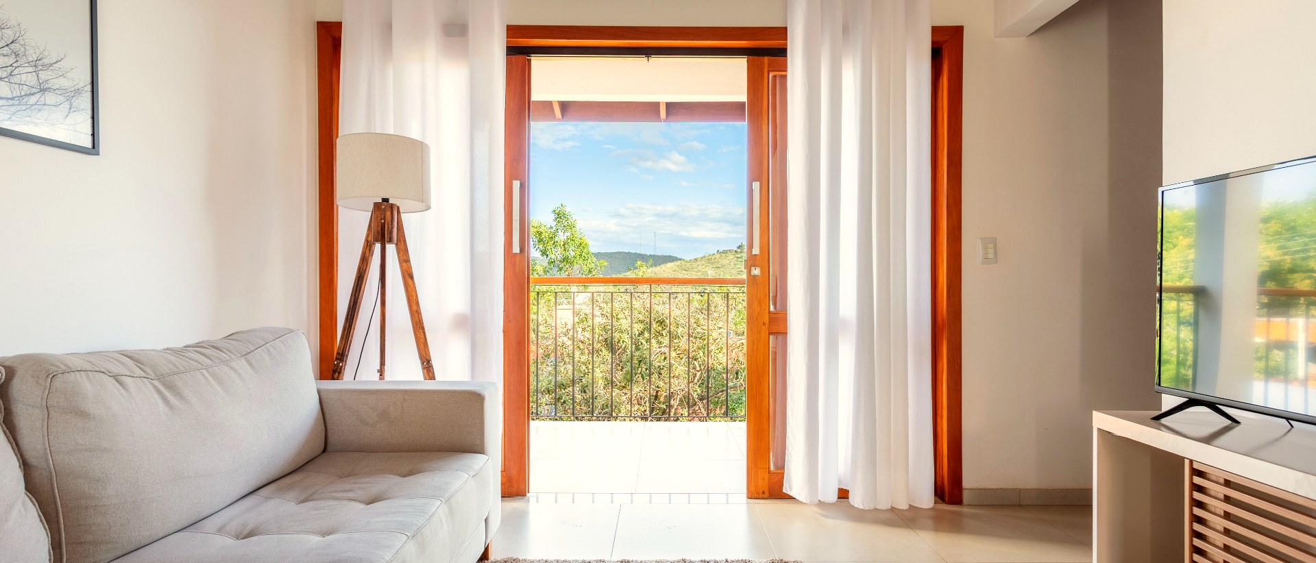 Sala de estar do apartamento Cerrado Ville com varanda aberta e vista para a Chapada dos Veadeiros